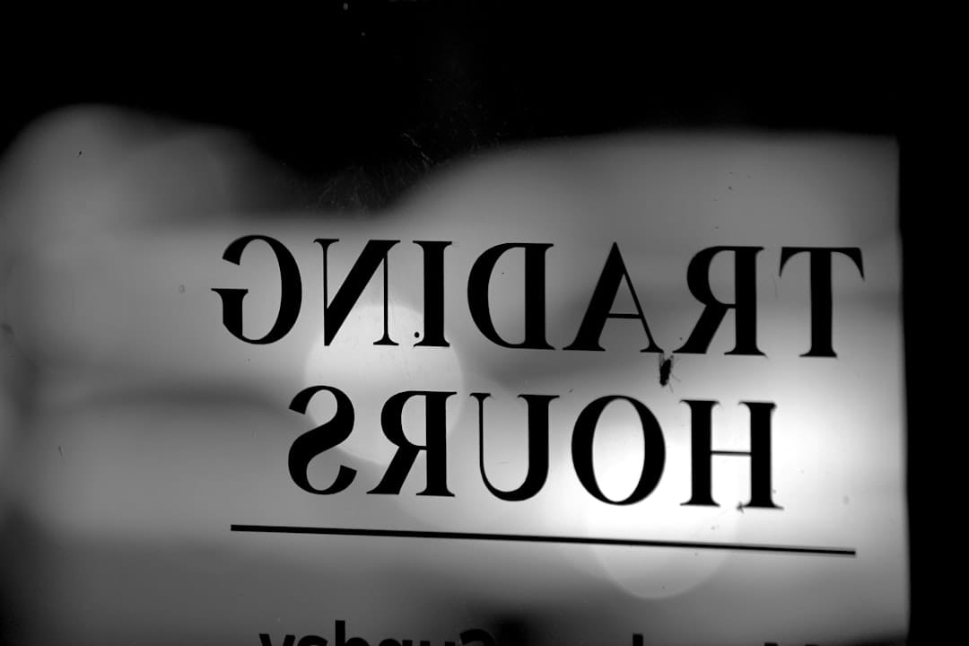 A black and white photo of a trading hours sign