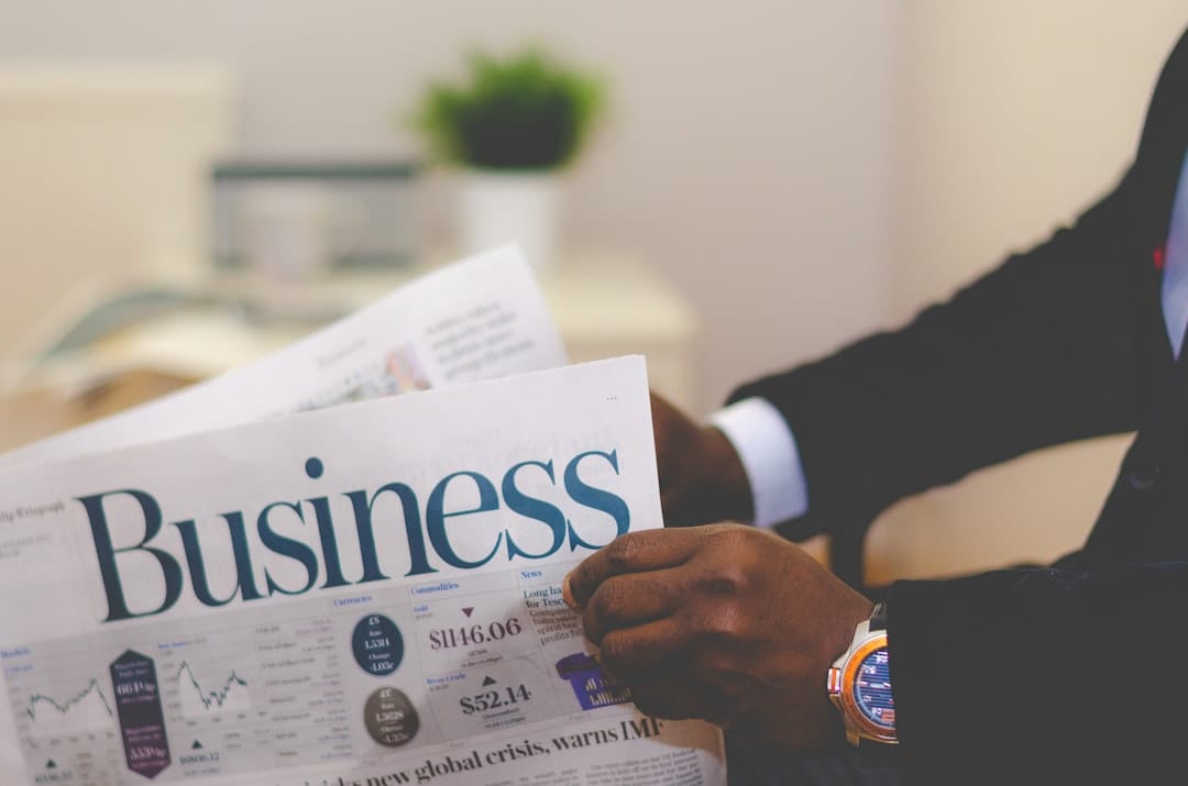 Person wearing suit reading business newspaper