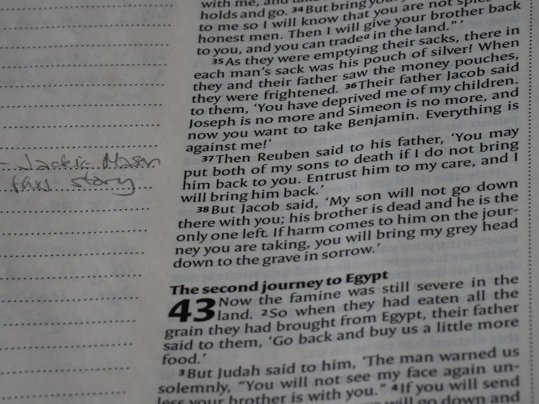 Handwritten notes beside bible text on page.