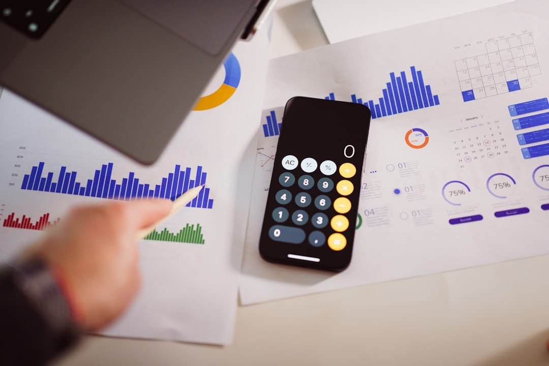 A calculator sitting on top of a table next to a laptop