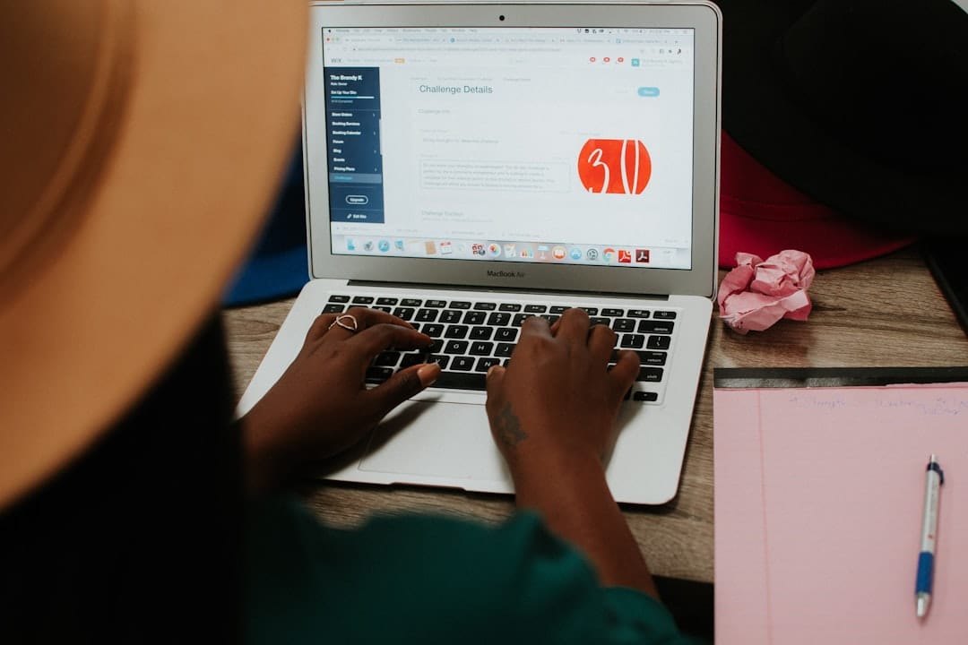 Person using macbook air on white table