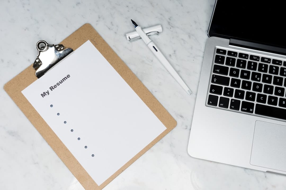 White printer paper beside silver laptop computer